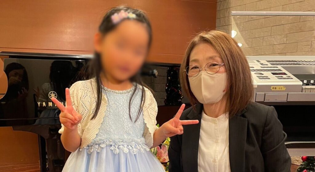 女の子と先生のコンクール記念写真