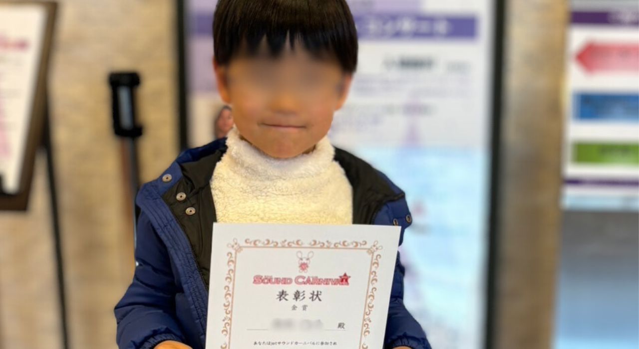 表彰状を持って微笑む男の子